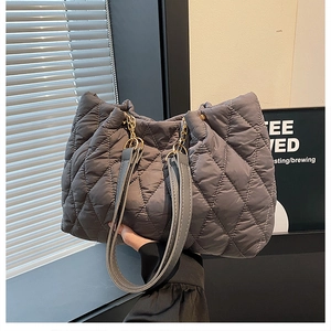Dettaglio borsa shopper trapuntata grigio scuro con catena dorata e manico in pelle