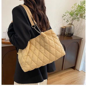 Dettaglio della borsa shopper trapuntata beige chiaro con catena in metallo e rombi