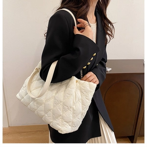 Dettaglio della borsa tote trapuntata beige con elegante motivo a rombi per donna