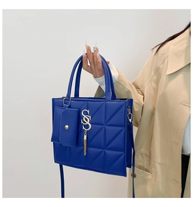 Close-up of Klein Blue quilted tote bag with metal S-logo charm and tassel detail