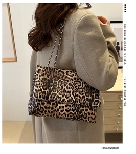 Close-up of leopard print crossbody bag featuring metal chain strap and suede texture