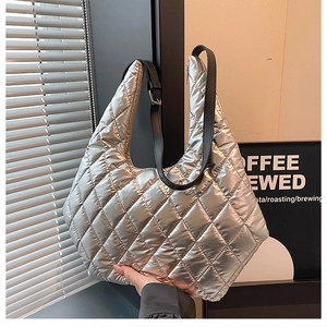 Detail of silver metallic quilted tote bag with diamond pattern and adjustable strap