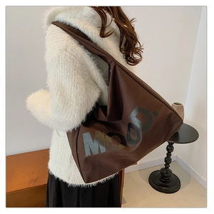 Dettaglio della borsa hobo in tela testa di moro con stampa MOOD. sulla spalla