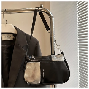 Details der schwarz-silbernen Patchwork-Achseltasche an einem minimalistischen Gestell