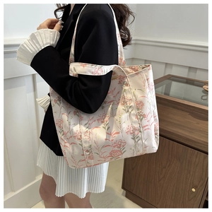 Detailed side view of floral canvas tote bag with shoulder straps and exterior pocket