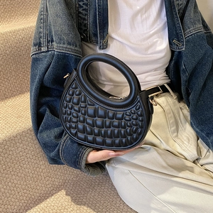 Chic black crescent shoulder bag with embossed texture and circular top handle