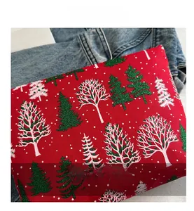 Détail d'une pochette de Noël rouge avec sapins pailletés sur tissu canevas festif
