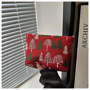 Detail der roten Weihnachtstasche mit Tannenbaummuster und glitzernden Schneeflocken