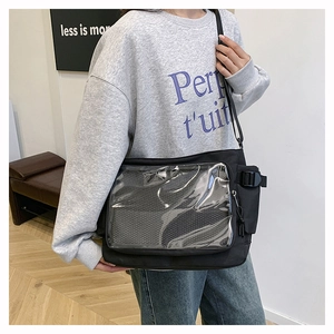 Detail of black canvas messenger bag with transparent PVC window for badges and accessories