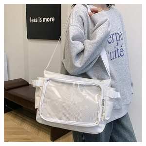 Detail of white nylon messenger bag featuring a transparent mesh front pocket and wide strap