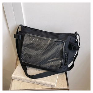 Detail view of black casual messenger bag featuring a transparent mesh front pocket
