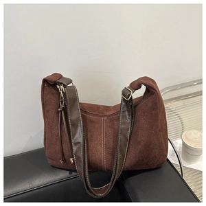 Détail du sac bandoulière en daim marron avec coutures verticales et boucle dorée
