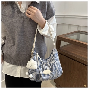Detail of blue plaid knit tote bag with adjustable strap and cloud plush charm