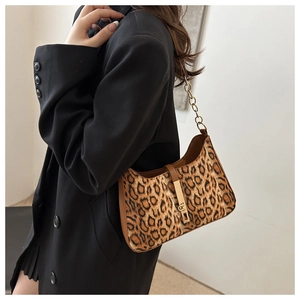 Détail du sac léopard avec bandoulière en chaîne dorée et bordure en cuir marron