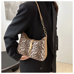 Détail du sac sous l'aisselle à motif léopard avec chaîne dorée et fermoir pivotant
