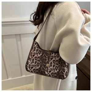 Détail du sac léopard avec bandoulière en cuir marron et boucle dorée élégante