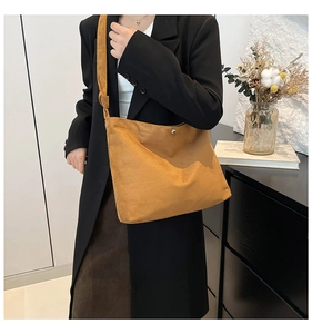 Close-up of brown corduroy tote bag showing soft ribbed texture and decorative strap knot