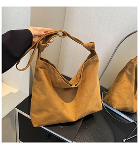 Detail of brown frosted suede tote bag with knotted strap and magnetic closure