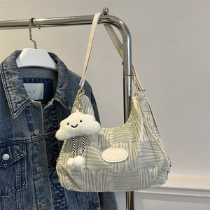 Mint green plaid tote bag with cloud charm and white leather patch on denim jacket