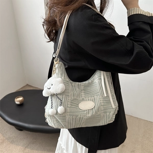 Minimalist light green geometric tote bag with cloud pendant shown on a model