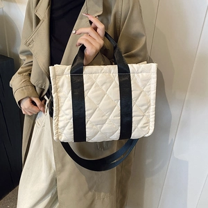 Quilted beige tote bag with black straps and large capacity for daily commuting