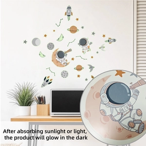 Luminous astronaut and space wall decals glowing on a white wall in a modern room