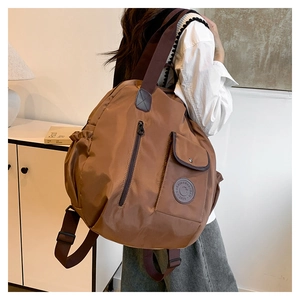 Detail of dark brown waterproof backpack with side pockets and a round logo patch