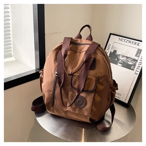 Detail of the brown multi-functional backpack showing waterproof fabric and side pocket