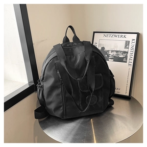 Detail view of the black lightweight nylon backpack on a modern metal table