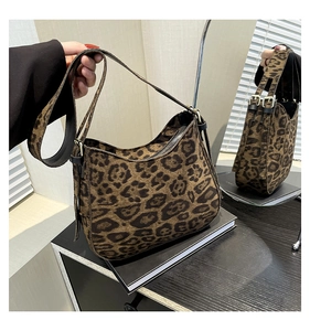 Close-up of leopard print shoulder bag featuring metal zipper and adjustable strap