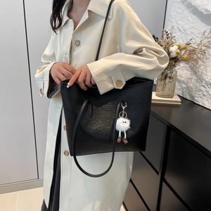 Large capacity black tote bag with embossed pattern and plush doll charm for women