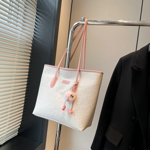 Minimalist white tote bag with pink trim, embossed icons and a plush charm on a hanger