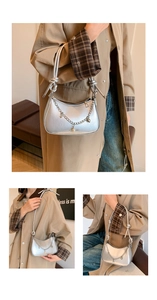 Detailed silver shoulder bag featuring metallic leather and elegant pearl chain pendant