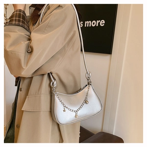 Silver crescent shoulder bag with metallic finish and star charms on socialite model