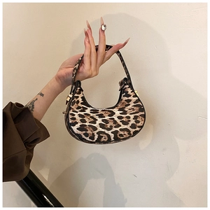 Close-up of leopard print crescent bag with smooth texture and sleek black edge finish