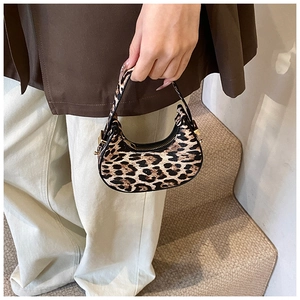 Detailed shot of leopard print crescent bag with black zipper and gold metal buckles