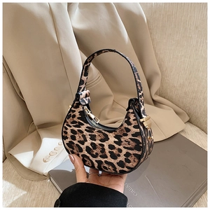 Detail of leopard print crescent bag with gold hardware and lychee textured faux leather