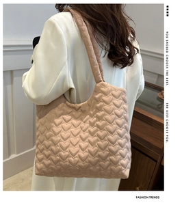 Detail of heart-quilted texture on oversized beige tote bag for winter casual wear