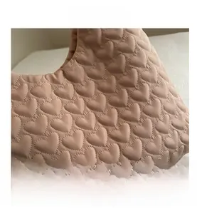 Close-up of the heart-shaped quilting and fine stitching on this pink puffer tote bag