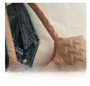 Detail of heart-shaped quilted stitching on a soft dusky pink padded shoulder bag