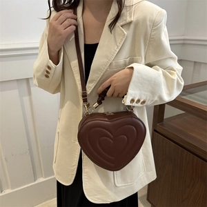 Deep brown heart-shaped handbag with triple heart embossed pattern and gold hardware
