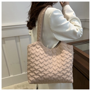 Detailed close-up of pink tote bag with quilted heart pattern and soft glossy finish