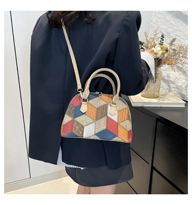 Detailed view of the multi-colored geometric patchwork shell bag on a model shoulder