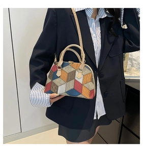 Détail du sac à main dôme à motifs géométriques et bandoulière sur un blazer