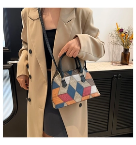 Détail d'un sac à main bicolore au design géométrique avec finitions métalliques dorées