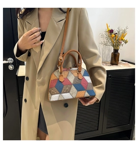 Detail of multi-color geometric shell bag made of PU leather with golden hardware
