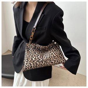 Detail of leopard print shoulder bag featuring amber resin chain and brown leather strap