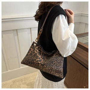 Detalle de bolso leopardo con cadena de acrílico ámbar y acabados de ojales metálicos