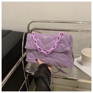 Détail d'un sac à bandoulière matelassé violet clair avec chaîne en plastique