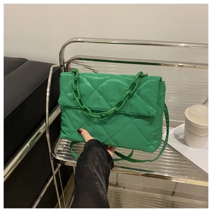Détail du sac matelassé vert fluo avec sa chaîne épaisse et sa bandoulière chic